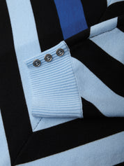 Close-up of a light blue sweater with black and white stripes and button details.