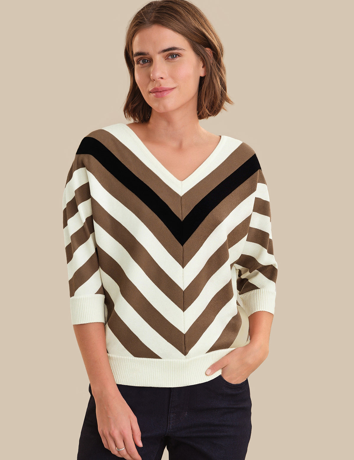Woman wearing a striped sweater with a neutral background