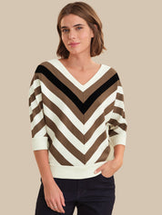 Woman wearing a striped sweater with a neutral background