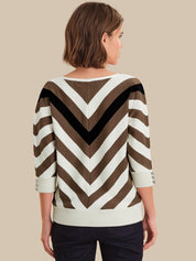 Woman wearing a brown and white striped sweater on a beige background