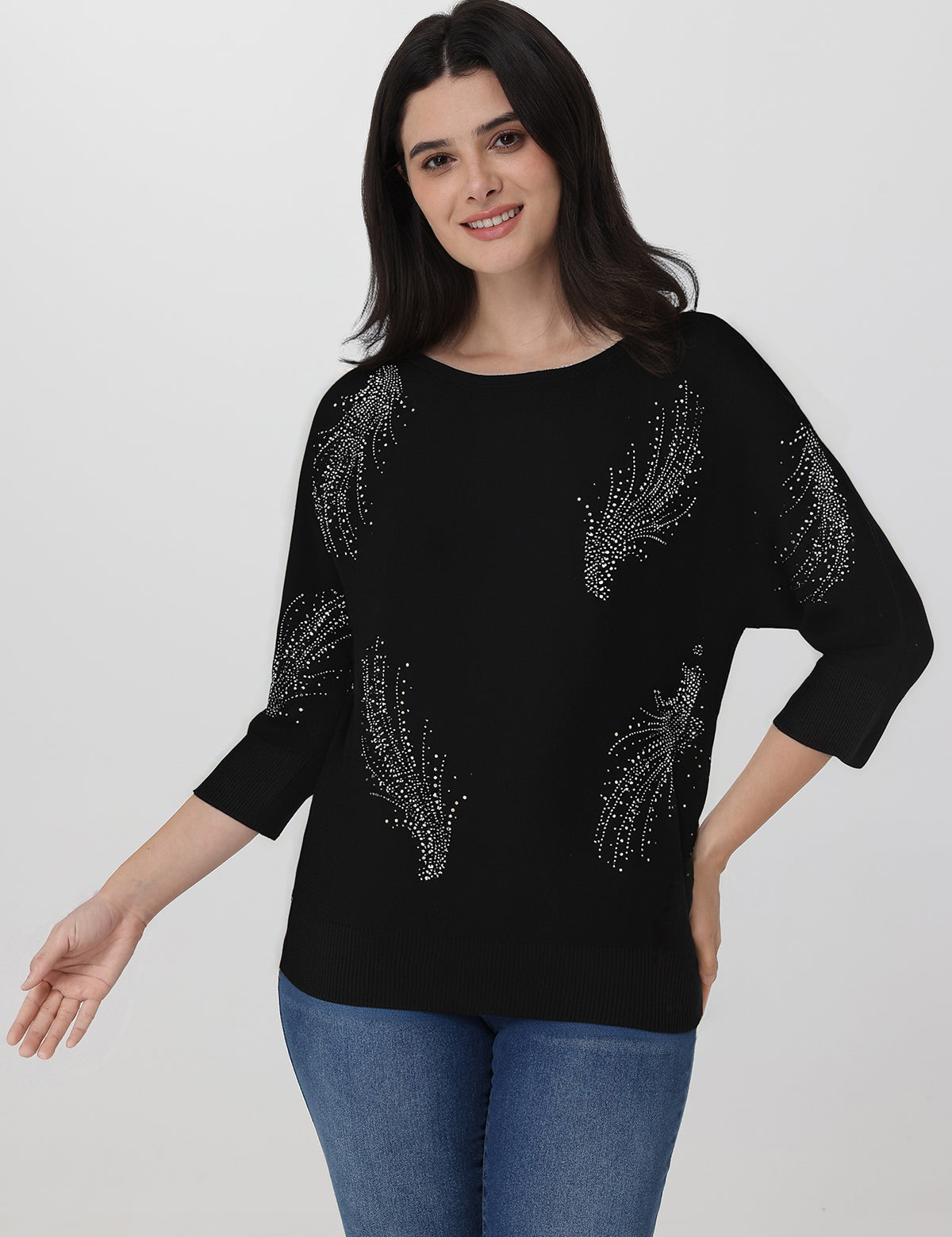 Woman wearing a black sweater with silver embellishments on a white background