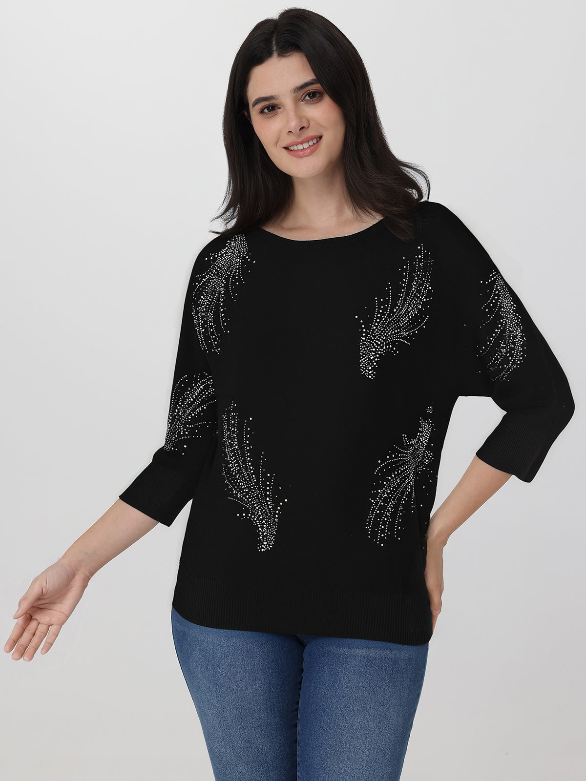 Woman wearing a black sweater with silver embellishments on a white background