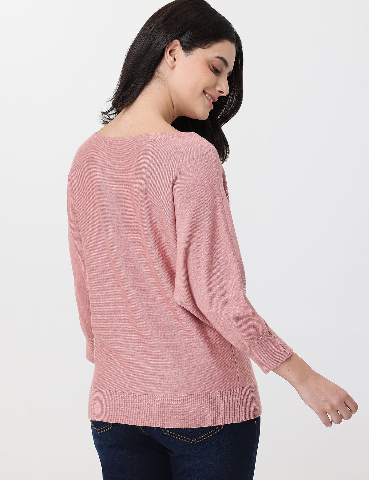 Woman wearing a pink sweater on a white background