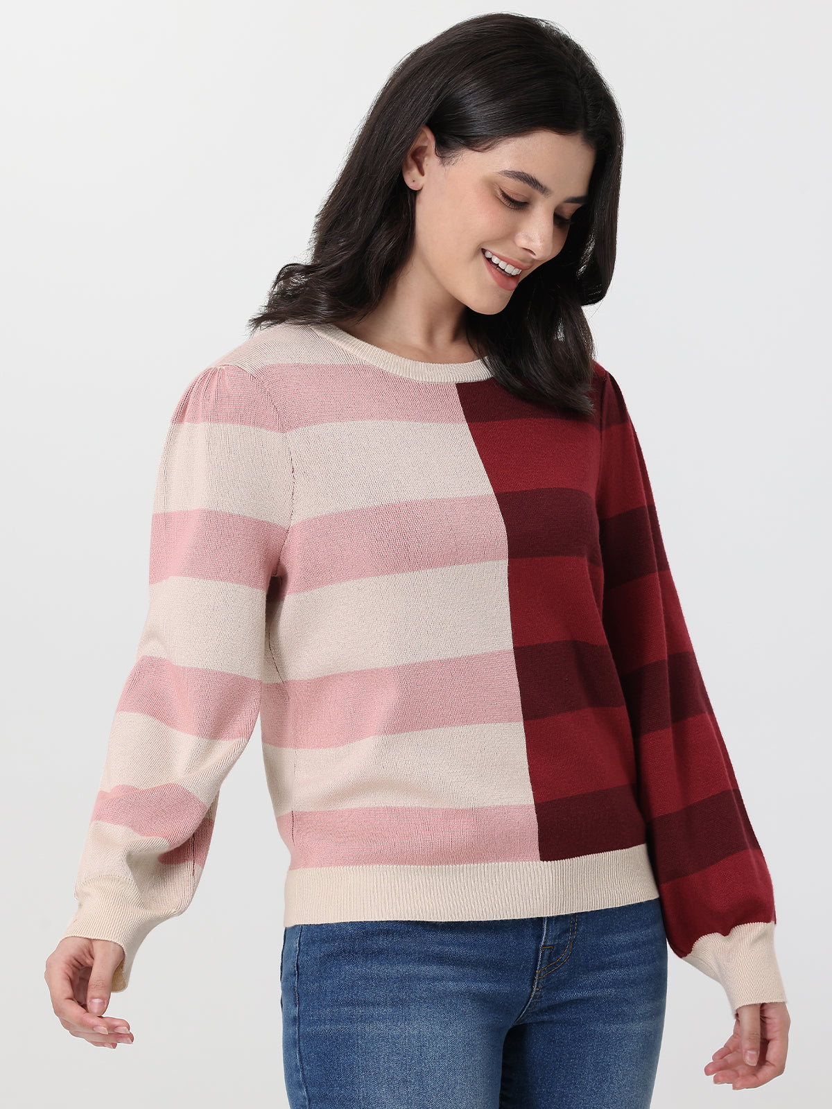 Woman wearing a sweater with pink and red plaid pattern on a white background