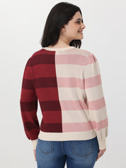 Woman wearing a checkered sweater with red, pink, and white stripes on a plain background