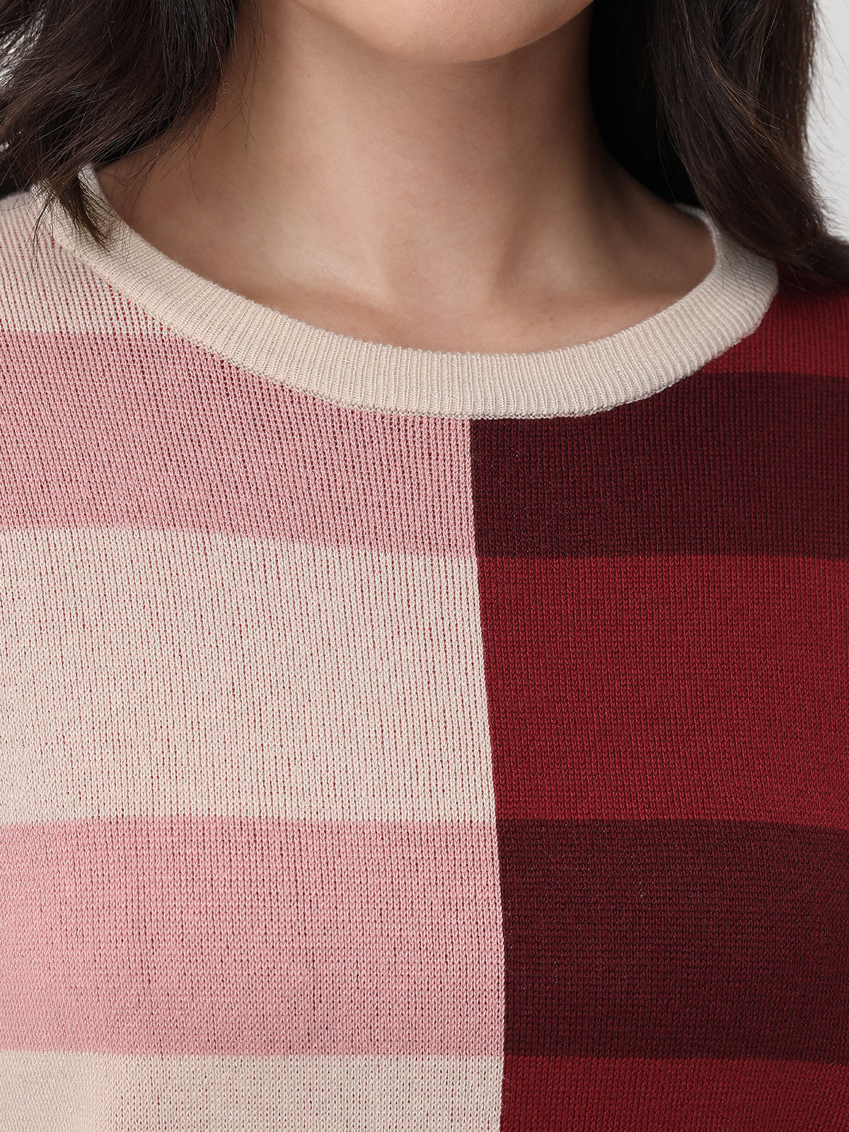 Close-up of a person wearing a sweater with pink and red horizontal stripes.