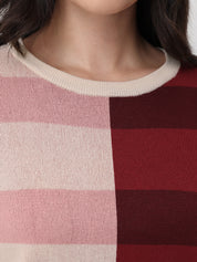 Close-up of a person wearing a sweater with pink and red horizontal stripes.