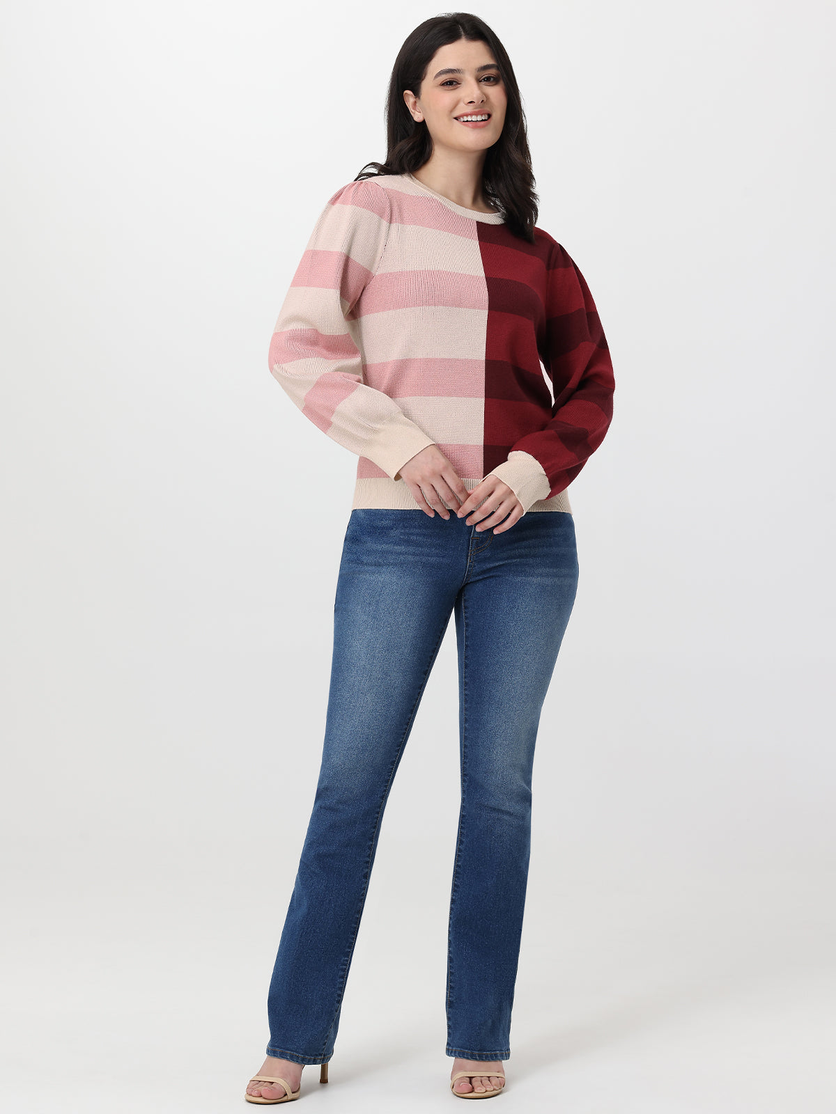 Woman wearing a striped sweater and blue jeans on a white background