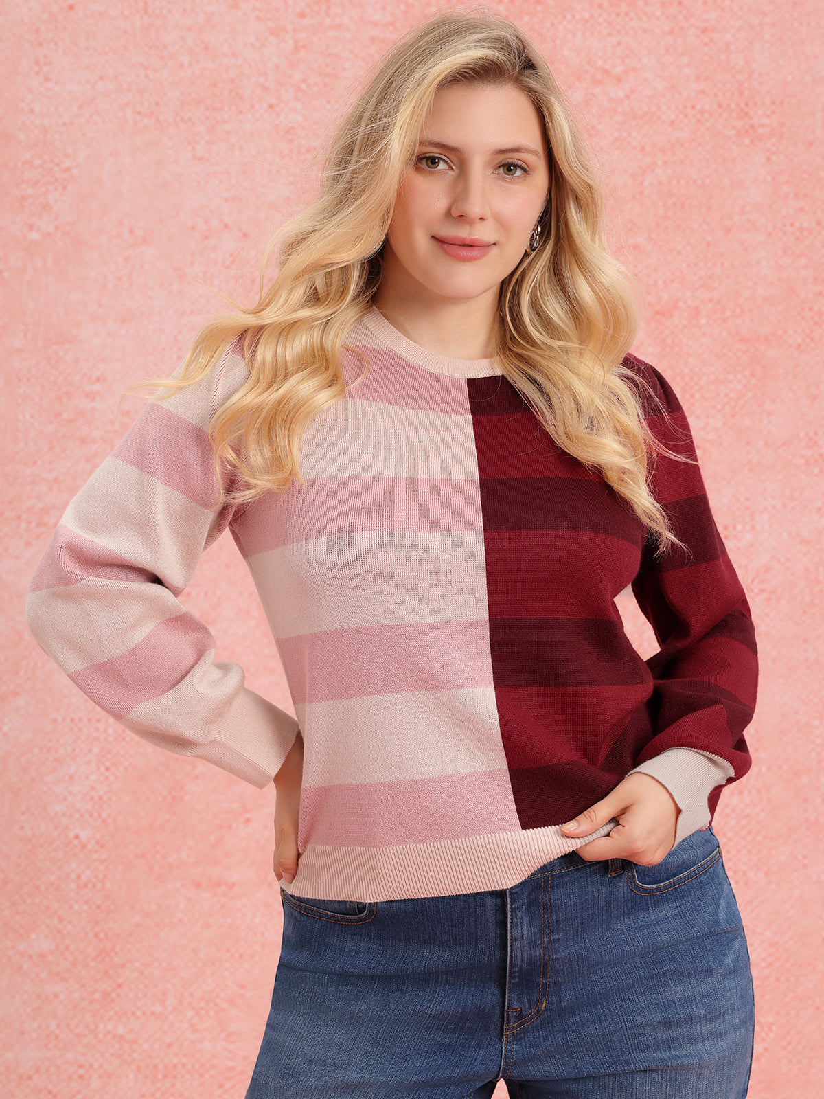 Woman wearing a pink and red striped sweater against a pink background
