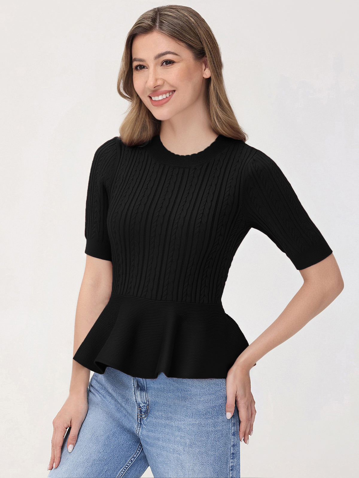 Woman wearing a black peplum top and blue jeans on a white background