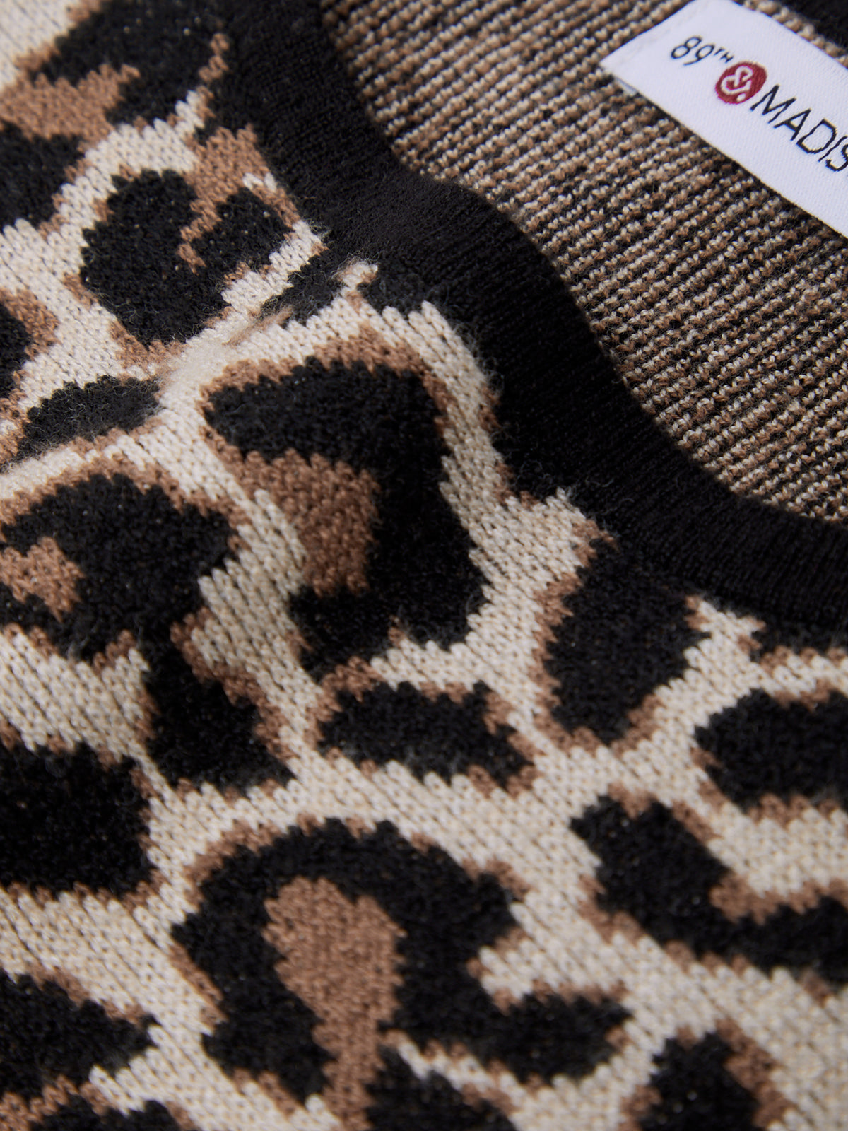 Close-up of a leopard print fabric with a visible brand label.