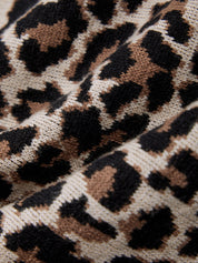 Close-up of a leopard print fabric with brown and black spots.