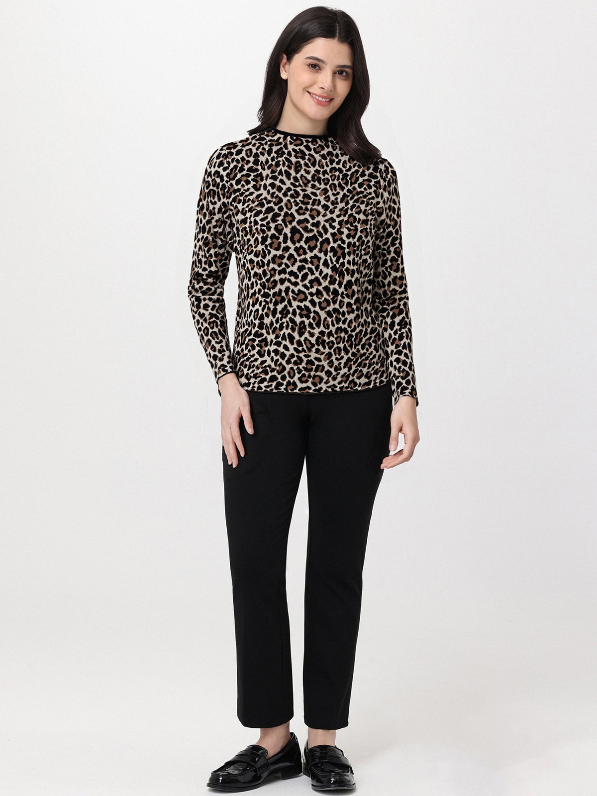 Woman wearing a leopard print top and black pants on a white background