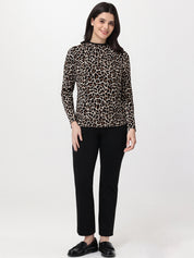 Woman wearing a leopard print top and black pants on a white background