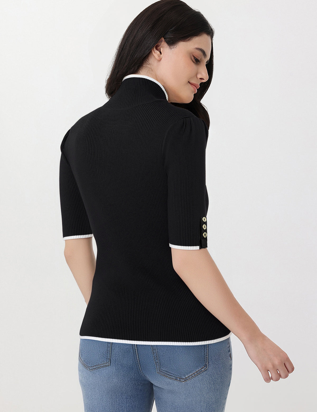 Woman wearing a black ribbed knit top with white trim on a white background