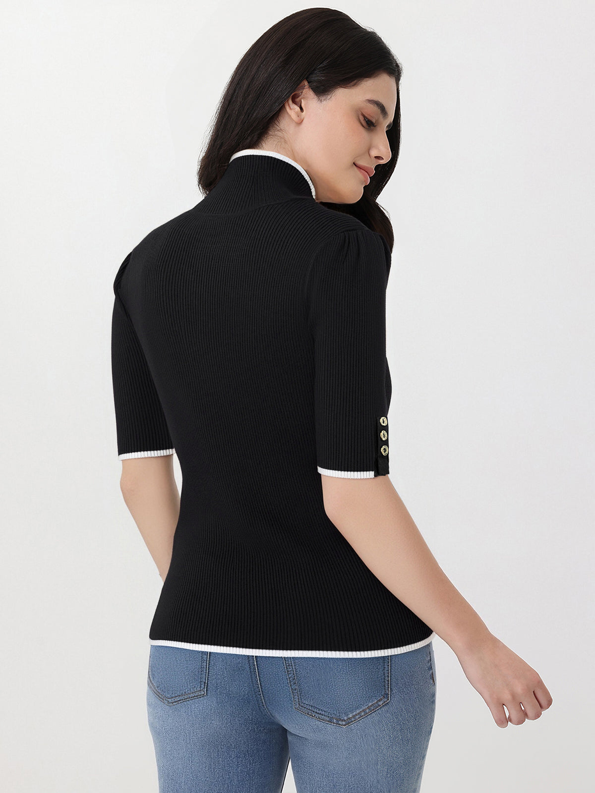 Woman wearing a black ribbed knit top with white trim on a white background