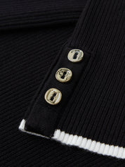 Close-up of a black ribbed sweater with gold buttons on a dark background