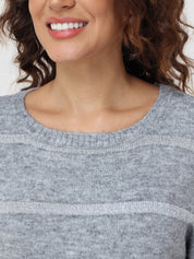 Close-up of a person wearing a gray sweater with a neutral background