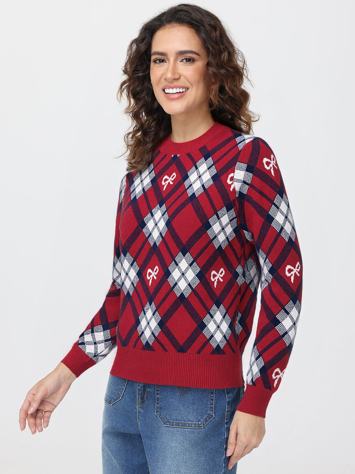 Woman wearing a red and blue plaid sweater with a pattern of white bows on a white background