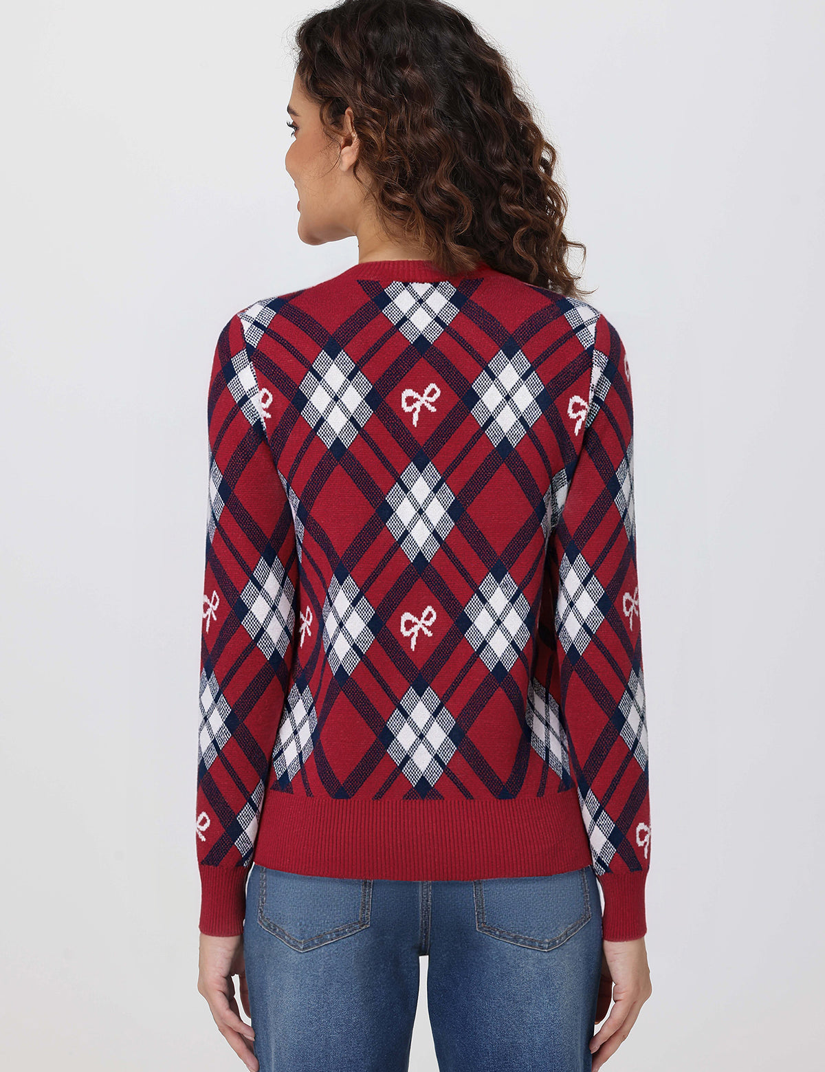 Woman wearing a red and blue plaid sweater with bow designs on a white background