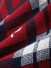 Close-up of a red, black, and white checkered fabric with a visible stain.