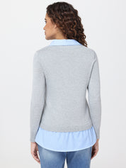 Woman wearing a gray sweater over a light blue striped shirt on a white background