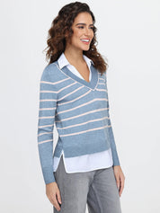 Woman wearing a blue striped sweater over a white shirt on a light gray background