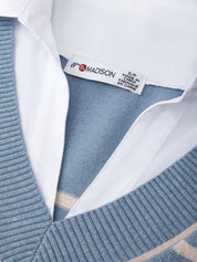 Close-up of a blue sweater with a visible brand label on a white background