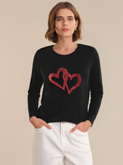 Woman wearing a black tops with red heart design on a beige background