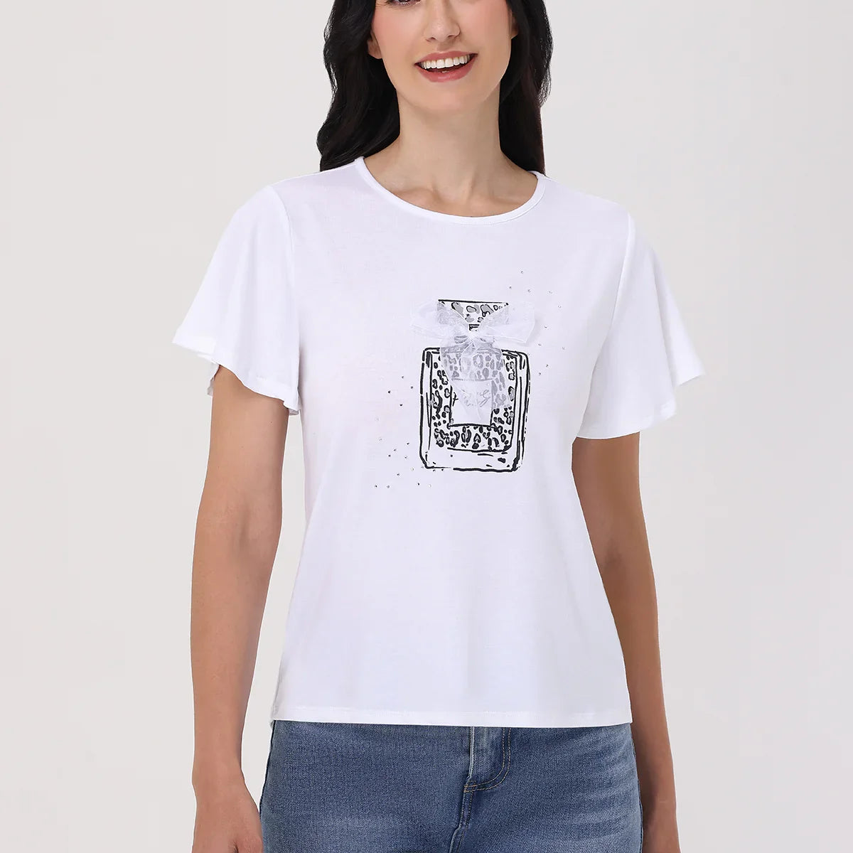 Woman wearing a white t-shirt with a black graphic design on a plain background