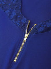 Close-up of a royal blue garment featuring a gold zipper and dark blue lace trim at the neckline.