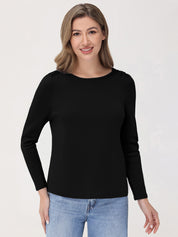 Woman wearing a black long-sleeve top and blue jeans on a white background