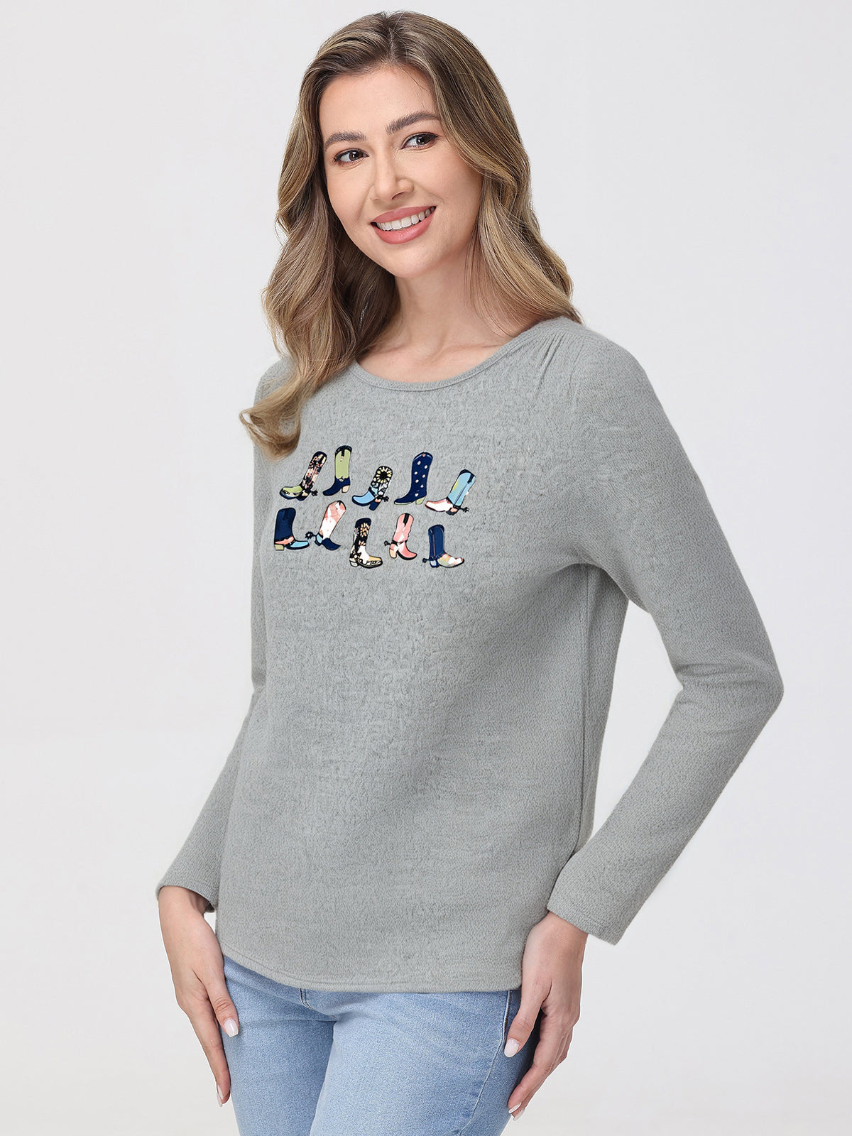 Woman wearing a gray top with colorful boot design on a white background
