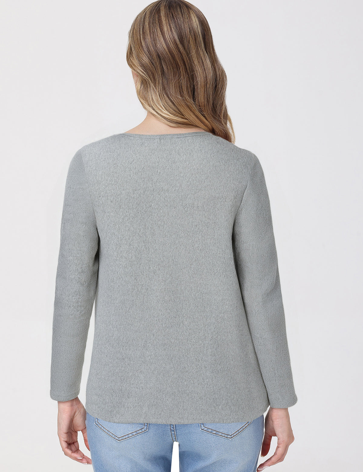 Person wearing a gray top and light blue jeans on a white background