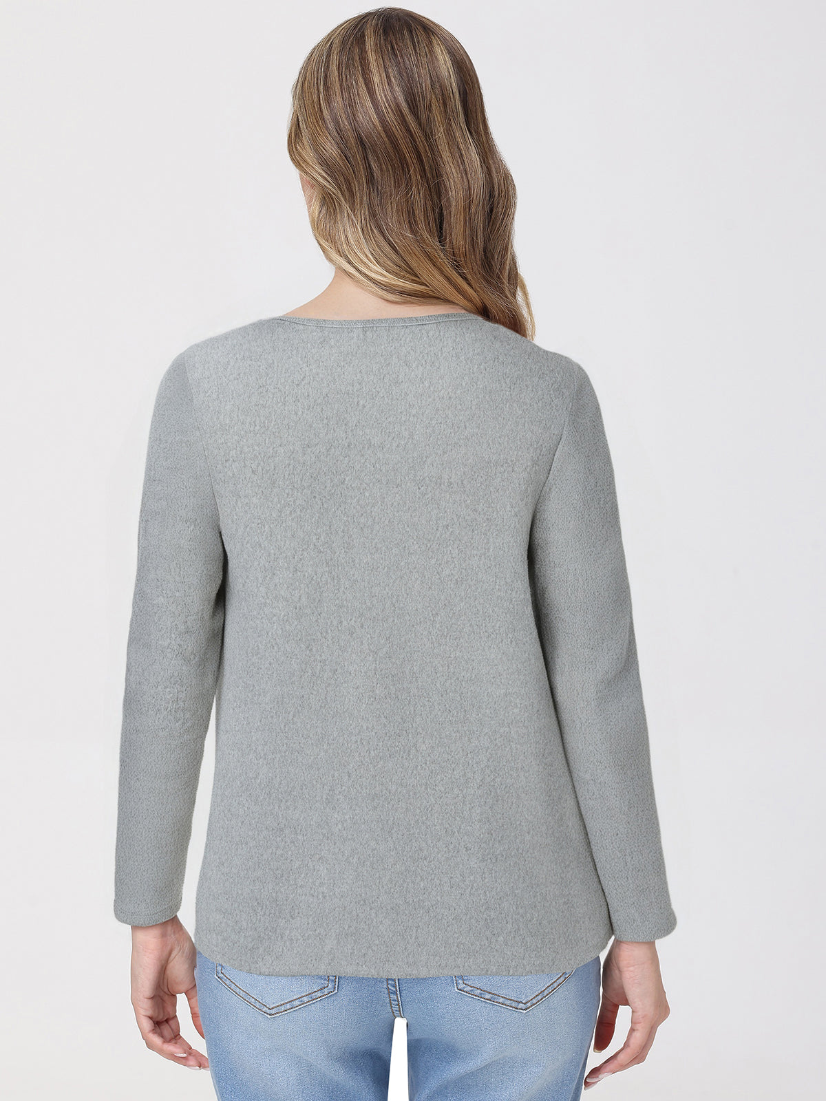 Person wearing a gray top and light blue jeans on a white background