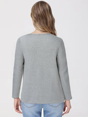 Person wearing a gray top and light blue jeans on a white background