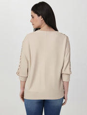 Woman wearing a beige sweater with rolled-up sleeves on a white background
