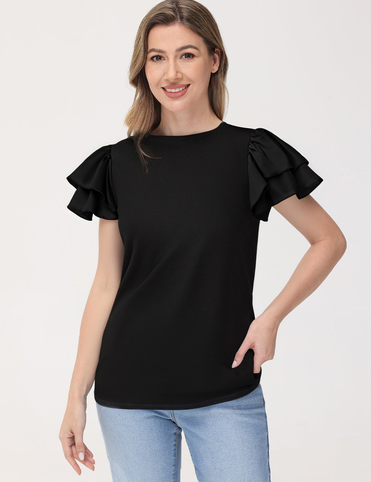 Woman wearing a black ruffled sleeve top against a white background