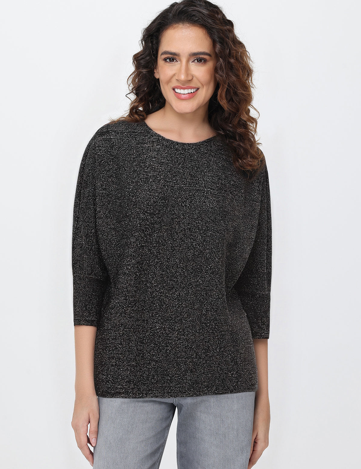 Woman wearing a black knit tops against a white background