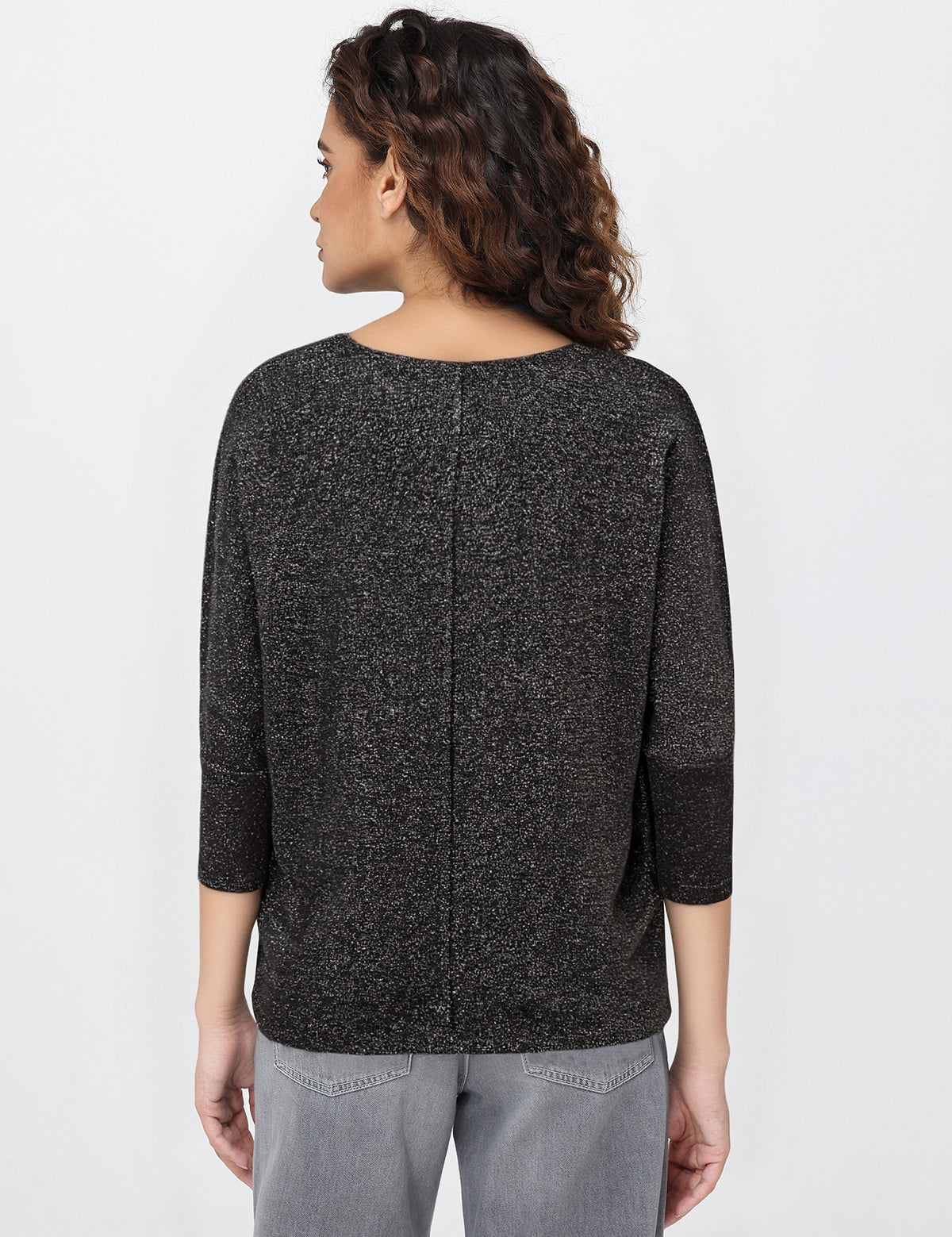 Woman wearing a black textured tops on a white background