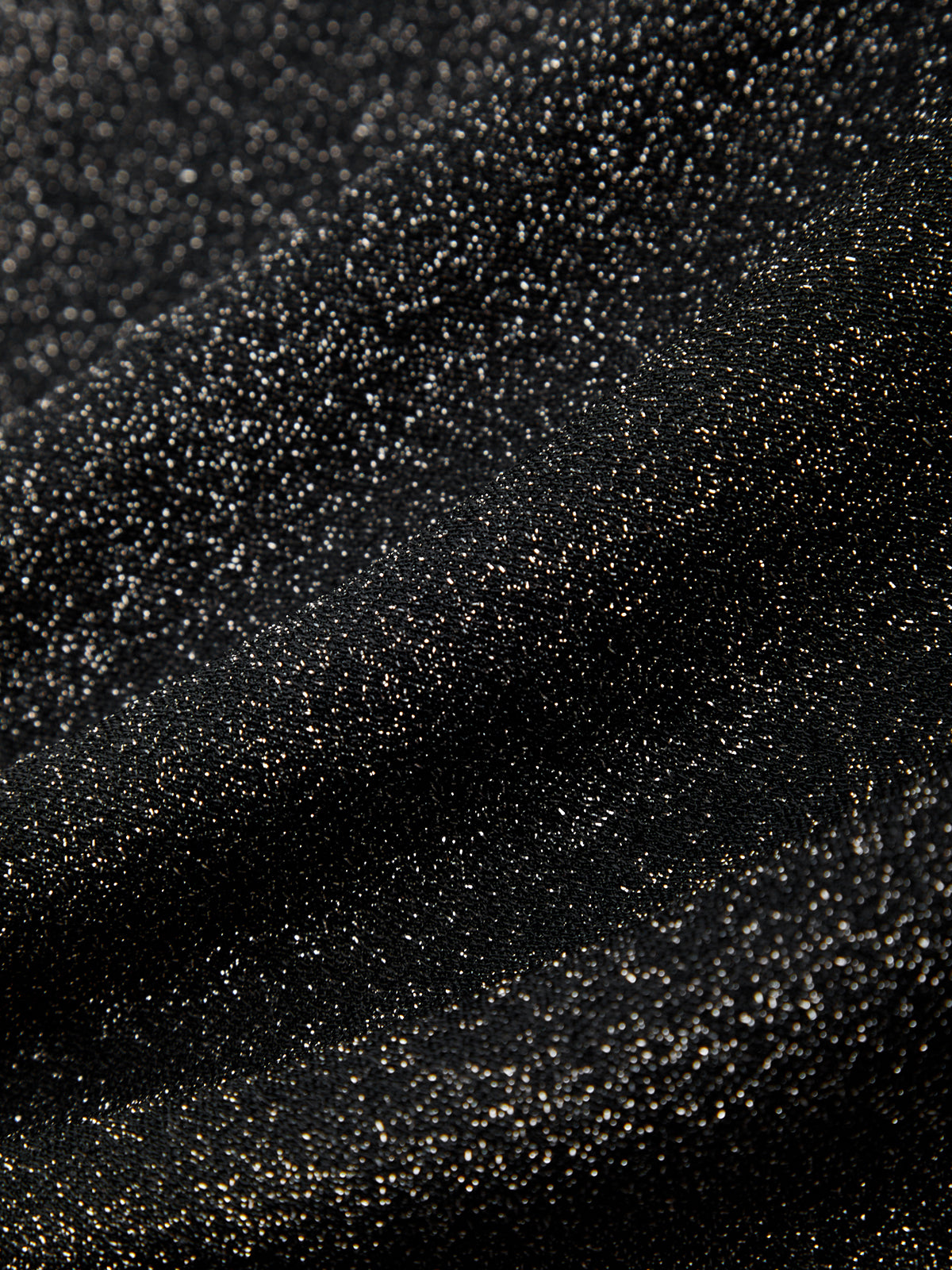 Close-up of black glitter on a black background