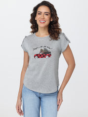Woman wearing a gray t-shirt with a graphic design on a white background