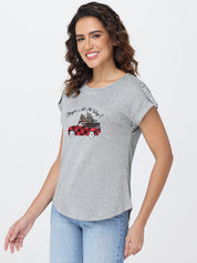 Woman wearing a gray t-shirt with a graphic design on a white background