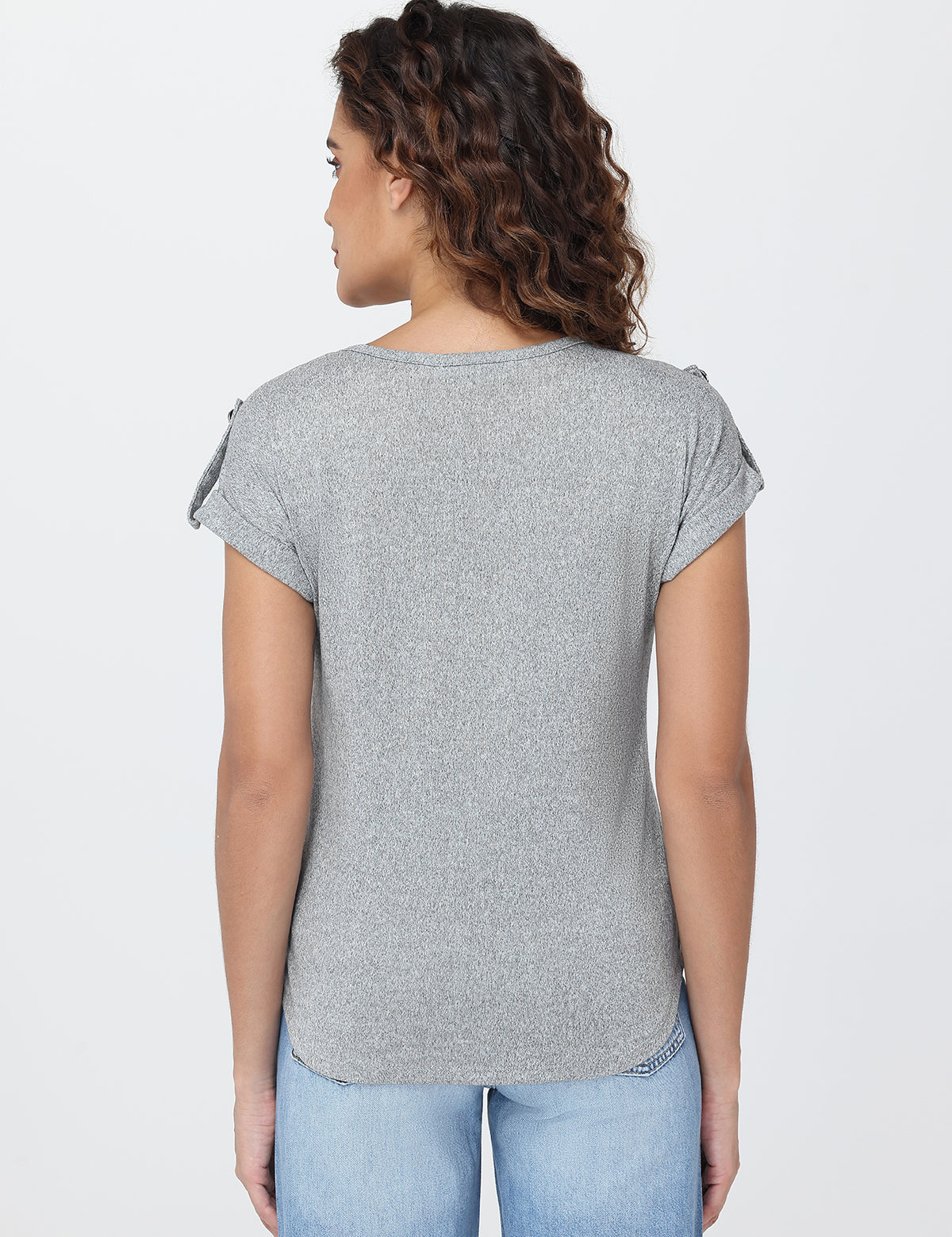 Woman wearing a gray t-shirt and blue jeans on a white background