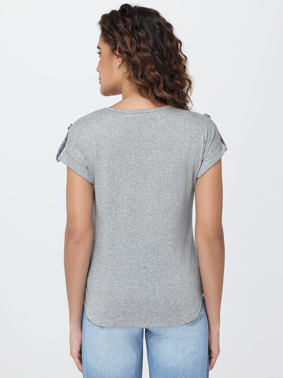 Woman wearing a gray t-shirt and blue jeans on a white background