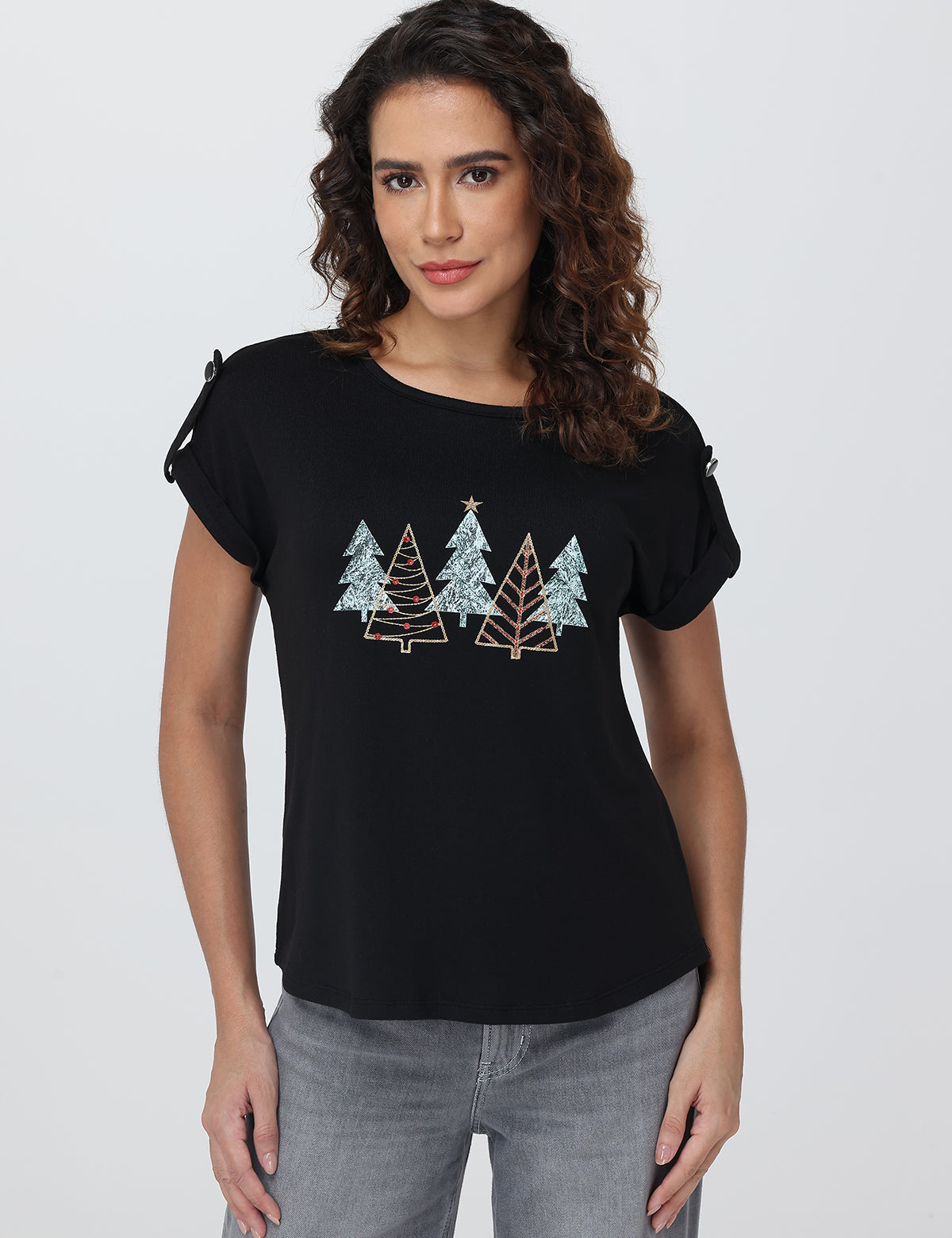 Woman wearing a black t-shirt with tree designs on a plain background