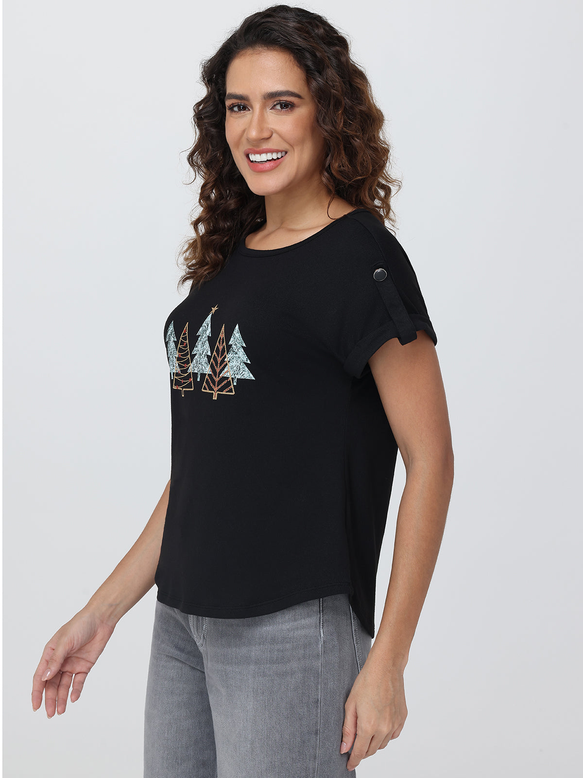Woman wearing a black t-shirt with a nature-themed design on a plain background