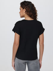 Woman wearing a black t-shirt and gray pants on a white background