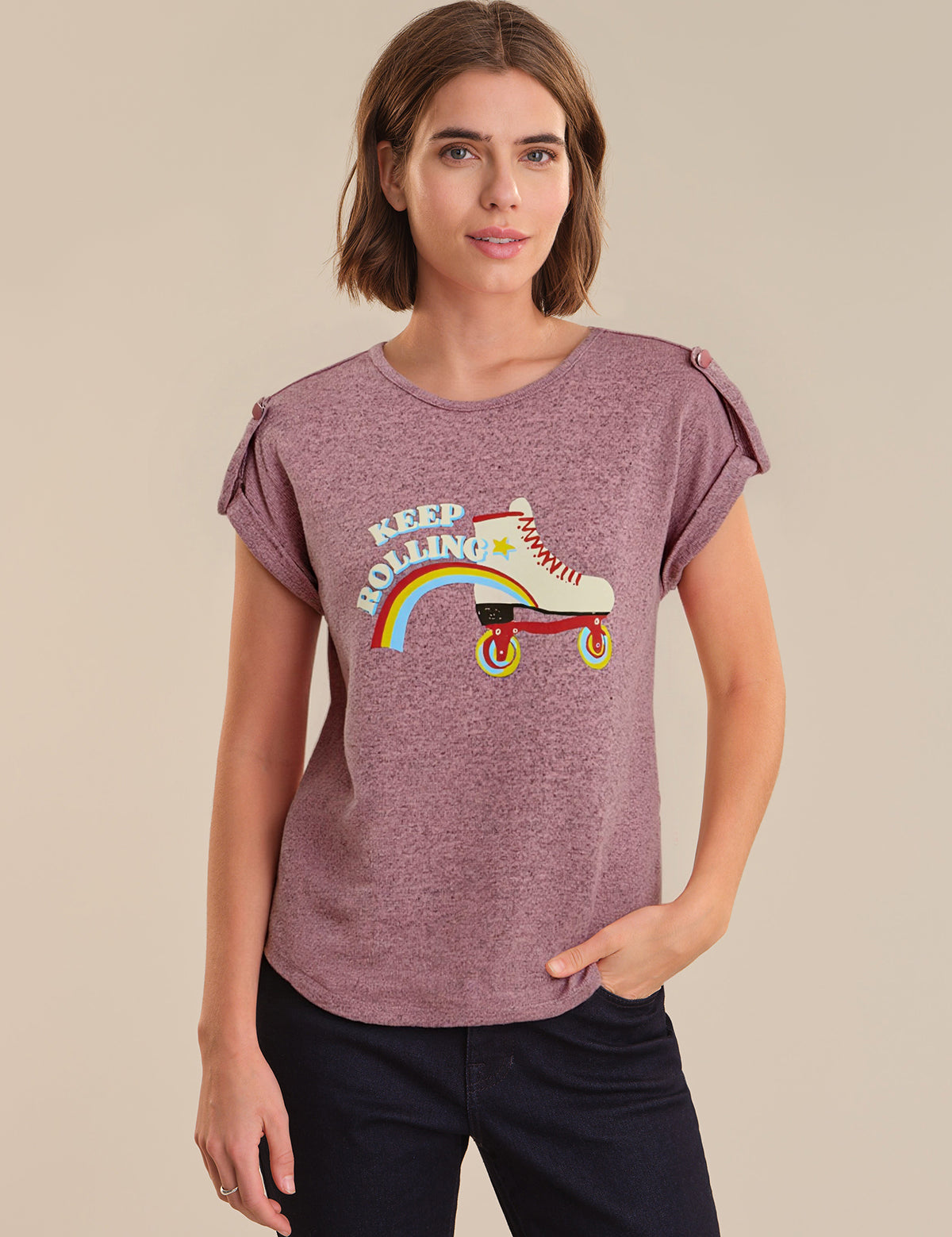 Woman wearing a purple t-shirt with a graphic design on a beige background