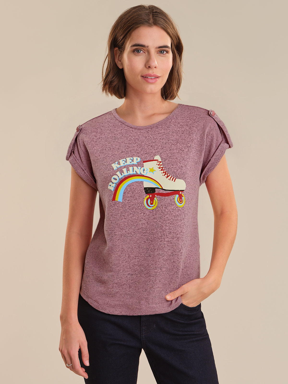 Woman wearing a purple t-shirt with a graphic design on a beige background